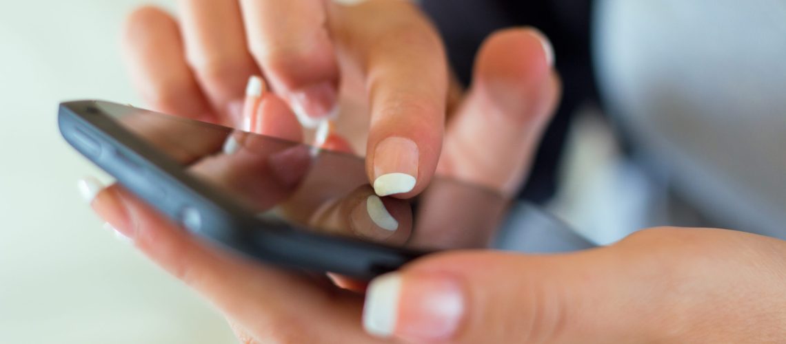 Portrait of beautiful young woman at home with mobile.